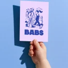 Babs geboortekaartje met een wandelend ouderpaar in de bergen, papa met de baby in een draagrugzak, in inktblauw op lila met de naam in blokletters
