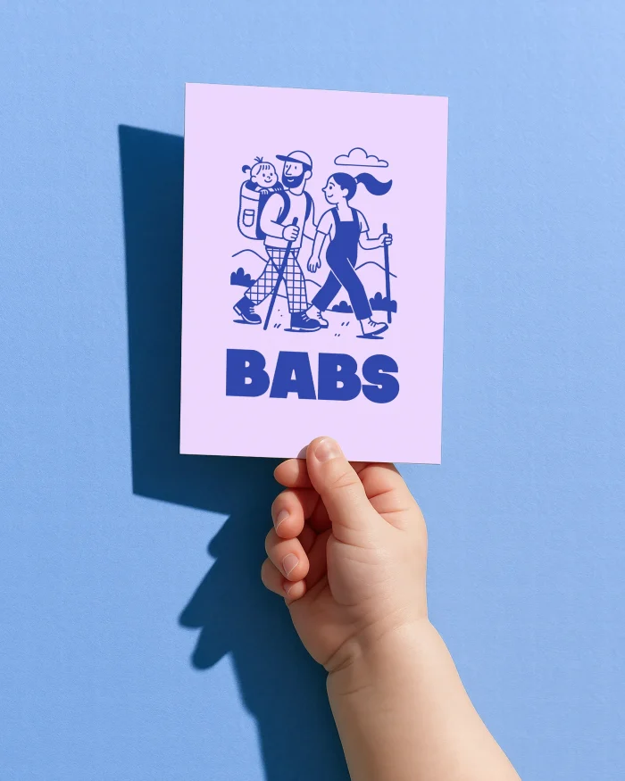 Babs geboortekaartje met een wandelend ouderpaar in de bergen, papa met de baby in een draagrugzak, in inktblauw op lila met de naam in blokletters