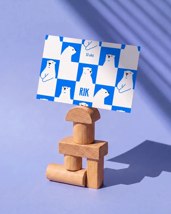 Rik geboortekaartje met vriendelijke ijsberen in een knalblauw-wit dambordpatroon en de naam tussen de beren verwerkt