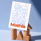 Mathis geboortekaartje met lichtblauwe doodles op wit en de naam groot in oranje, met een overdruk-effect waar oranje en blauw elkaar kruisen